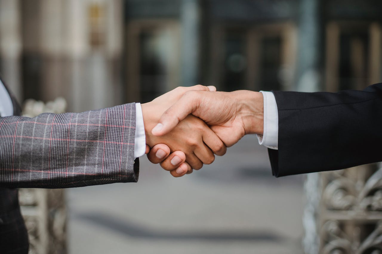 why-choose-us A close-up of two businesspeople shaking hands, symbolizing cooperation and partnership.